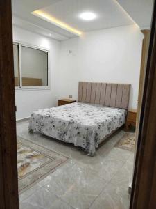 a bedroom with a bed in a room with a window at Maison lemjid in Kelibia