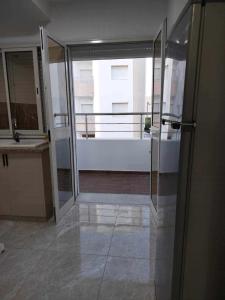an empty room with glass doors and a balcony at Maison lemjid in Kelibia +1 photo