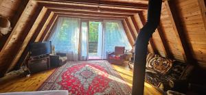 a living room with a tv and a large window at Domek Basia in Deskurów