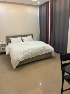a bedroom with a large bed and a table at City centre Apartment in Kigali