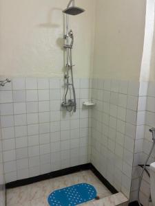 a bathroom with a shower with a blue mat on the floor at City centre Apartment in Kigali