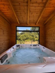 a large bath tub in a room with a window at Vila Kordhaku in Petrelë