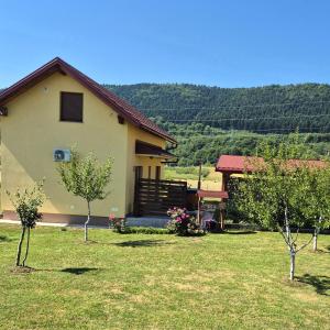 a house with a yard with trees in front of it at Kuća Trota - sauna, HOT TUB in Otočac
