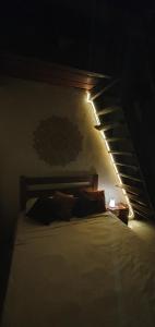 a bedroom with a bed with a light above it at Chalé Estalagem Vô Jasôn in Itamonte +8 photos
