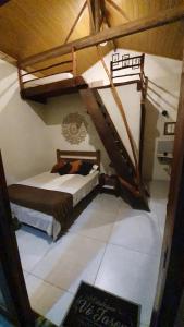 a bedroom with a bed in a room with a staircase at Chalé Estalagem Vô Jasôn in Itamonte