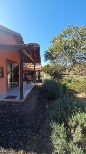 a house with a porch and a bench in a field at Chalé Estalagem Vô Jasôn in Itamonte
