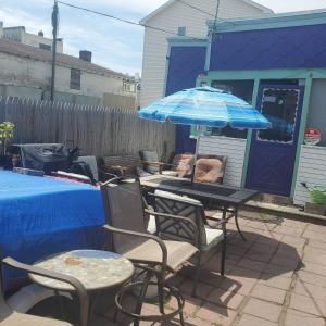 a patio with tables and chairs and an umbrella at ARMANI MANOR UPSTAIRS UNIT 3 quaint rustic 1br in Wildwood