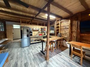 a kitchen with wooden floors and a table and a refrigerator at Cabaña Vivanco in Coveñitas