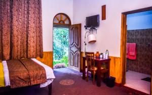 a bedroom with a bed and a bathroom with a door at MF Holiday Bungalow in Bandarawela