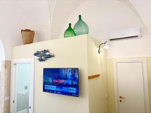 a room with a tv on a wall with two vases at A casa di Marina Mare Centro posto auto in zona in Porto Cesareo