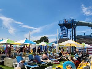 a group of people sitting in chairs and umbrellas at an amusement park at Spacious accomodation 188 Unity Beach sleeps 6 Centrally located Pet friendly Pets Stay Free in Brean