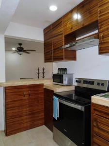 eine Küche mit Holzschränken und einem schwarzen Herdofen in der Unterkunft Casa Las Brisas in Progreso