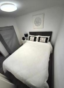 a bedroom with a large white bed with two pillows at T1 Amadora in Amadora