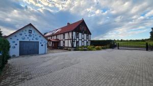 a white and black building with a driveway at Zacisze 13 in Leśna
