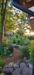 a garden with rocks and a tree and flowers at Esterka Village in Esterka