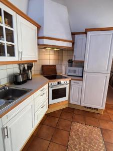 a kitchen with white cabinets and a sink at Ferienwohnung Frieda in Bückeburg