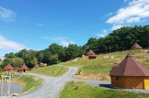 a winding road leading to a village with huts at Bungalow Kotaventure in Le Mesnil-Villement