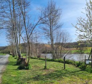 a path next to a river with trees and a road at Bungalow Kotaventure in Le Mesnil-Villement