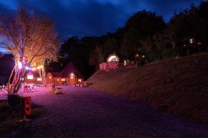 a group of people sitting on a hill at night at Bungalow Kotaventure in Le Mesnil-Villement