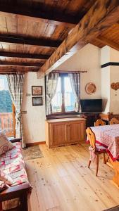 a living room with a table and a window at Gallio Appartamento con splendida vista in Gallio