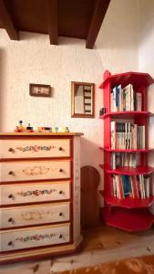 a bedroom with a dresser and a book shelf at Gallio Appartamento con splendida vista in Gallio