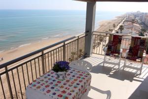 a balcony with a table and a view of the beach at Apartamentos Guillem in Playa de Miramar