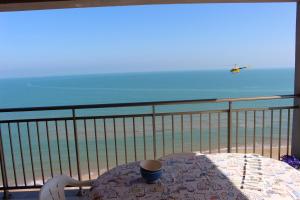 a table on a balcony with a view of the beach at Apartamentos Guillem in Playa de Miramar