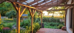 a wooden pergola on a house with a garden at Esterka Village in Esterka +26 photos