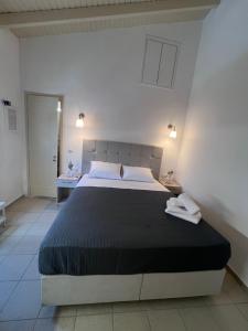a bedroom with a large bed with two towels on it at Kea Harbor 1 in Korissia