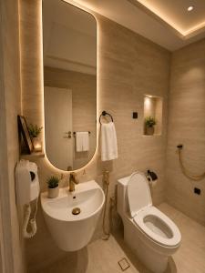 a bathroom with a sink and a toilet and a mirror at فندق وايت ويفس White Whiffs Hotel in Ad Darb
