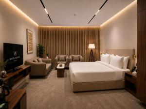 a hotel room with a bed and a television at فندق وايت ويفس White Whiffs Hotel in Ad Darb