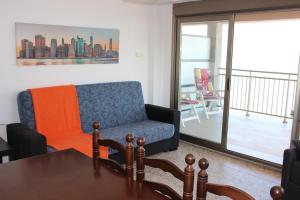 a living room with a couch and a table at Apartamentos Guillem in Playa de Miramar