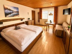 a bedroom with a large white bed in a room at Haus Dobrosek in Tröpolach