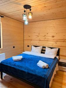 a bedroom with a bed with two towels on it at Tobani Cottage Kazbegi in Kazbegi