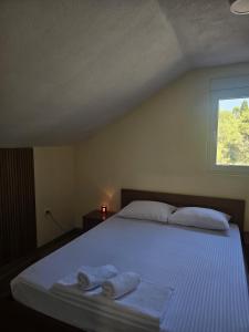 a bedroom with a bed with two towels on it at MontSky Apartment - Podgorica Airport in Mitrovići