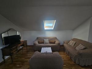 a living room with two couches and a television at MontSky Apartment - Podgorica Airport in Mitrovići +10 photos