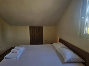 a bedroom with a bed with two towels on it at MontSky Apartment - Podgorica Airport in Mitrovići
