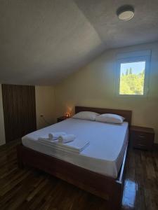 a bedroom with a large bed with a window at MontSky Apartment - Podgorica Airport in Mitrovići