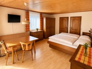 a bedroom with a bed and a wooden table at Haus Dobrosek in Tröpolach