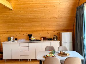a kitchen with wooden walls and a table and chairs at Tobani Cottage Kazbegi in Kazbegi +4 photos