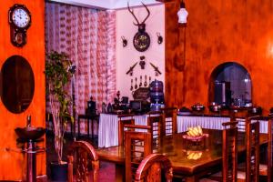 a dining room with a table and chairs and a clock at MF Holiday Bungalow in Bandarawela