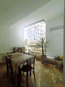 a dining room with a table and chairs and a window at Résidence nid d'abeille Béjaïa in Bejaïa