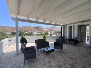 a covered patio with chairs and a table and mountains at Kea Harbor 2 in Korissia