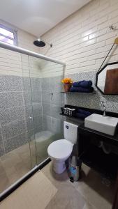 a bathroom with a toilet and a shower and a sink at Kitnet Tijolo Ecológico 02 in Tamandaré