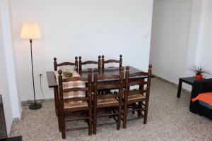 a dining room table and chairs in a room at Apartamentos Guillem in Playa de Miramar