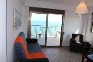a living room with a couch and a balcony at Apartamentos Guillem in Playa de Miramar