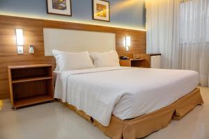 a bedroom with a large bed with a wooden headboard at Holiday Inn Express Belem Ananindeua by IHG in Belém +77 photos