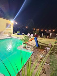 a swimming pool in a yard at night at Chácara Nunes in Ibiúna