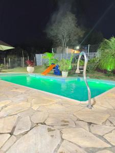 a swimming pool at night with a water slide at Chácara Nunes in Ibiúna