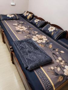 two beds with blue sheets with flowers on them at Shiddi pelesh yatri niwas in Maihar